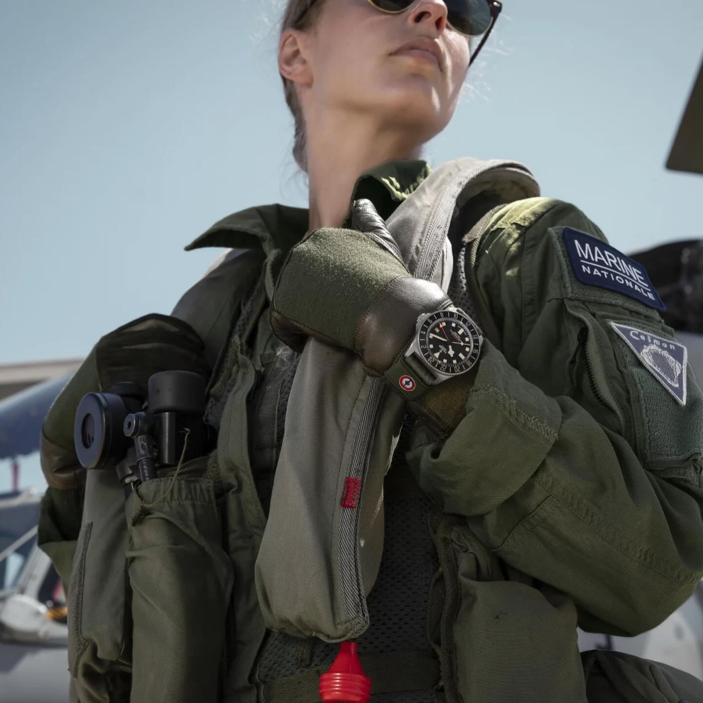 Bracelet en tissu vert militaire tissé par Julien Faure porté au poignet par une pilote de la Marine Nationale sur une montre Tudor Pelagos FXD GMT.