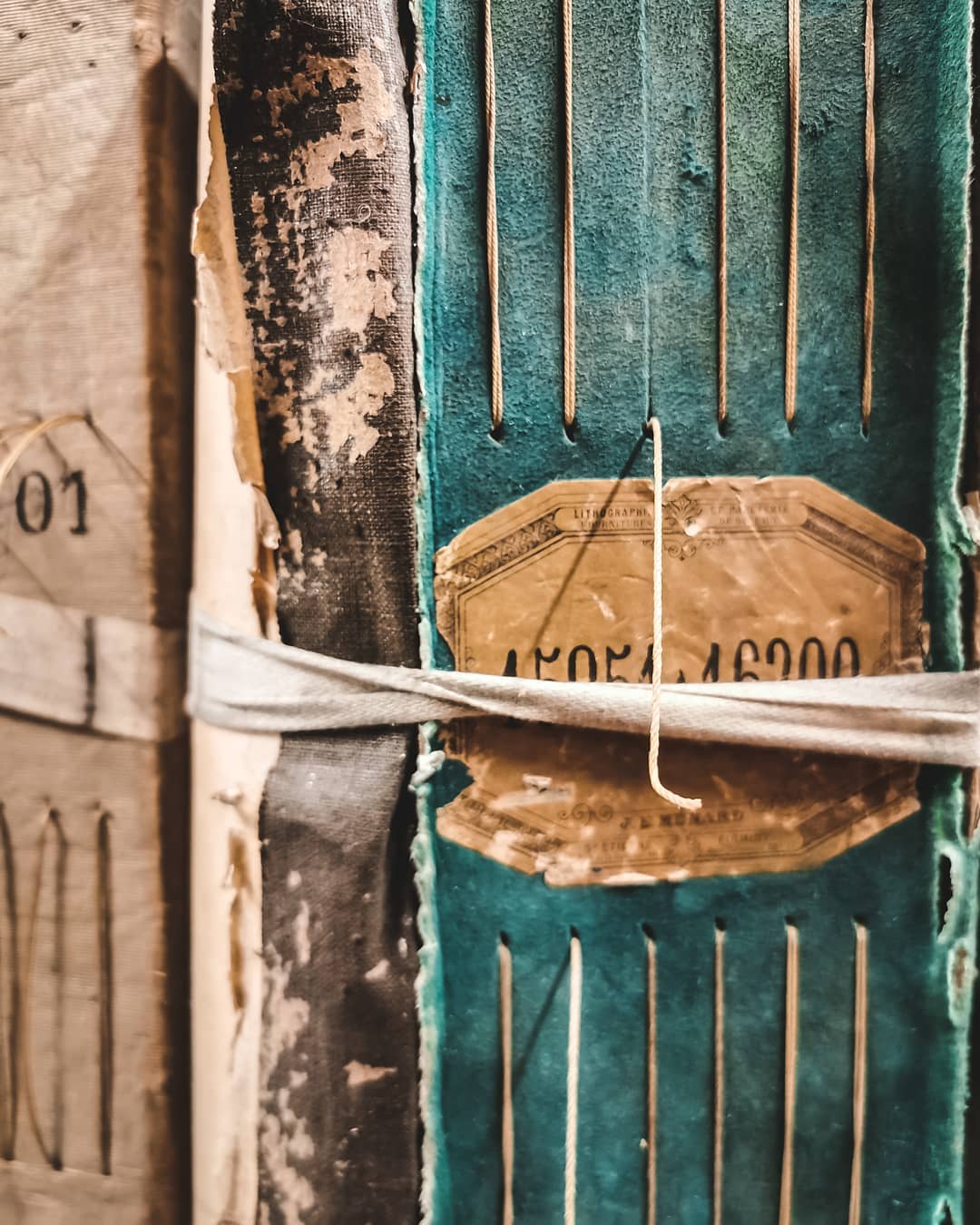 Dos de registre d'archives ancien turquoise avec reliure cousue et étiquette manuscrite.