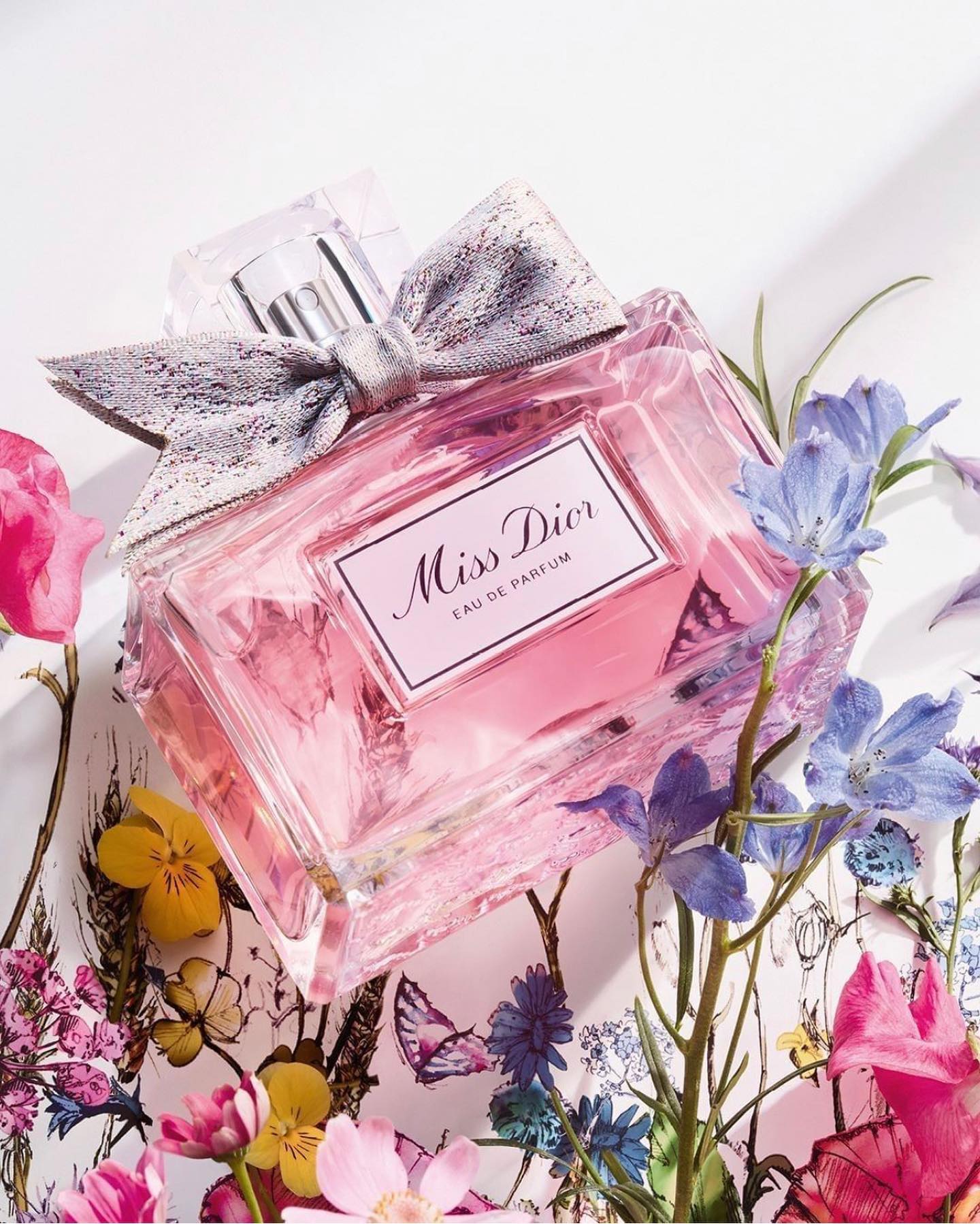 Flacon Miss Dior Eau de Parfum orné de son nœud poignard tissé en Jacquard par la Maison Julien Faure.