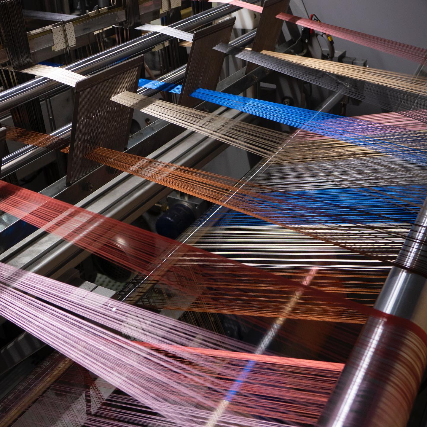Nappes de fils de chaîne multicolores tendues sur un métier à tisser industriel